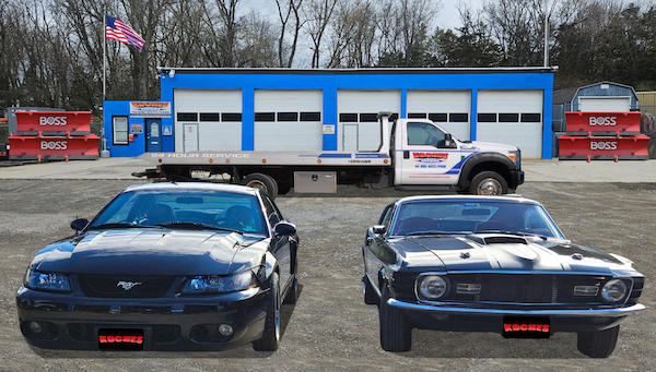 Koches auto repair shop with cars, a tow truck, and Boss snowplows